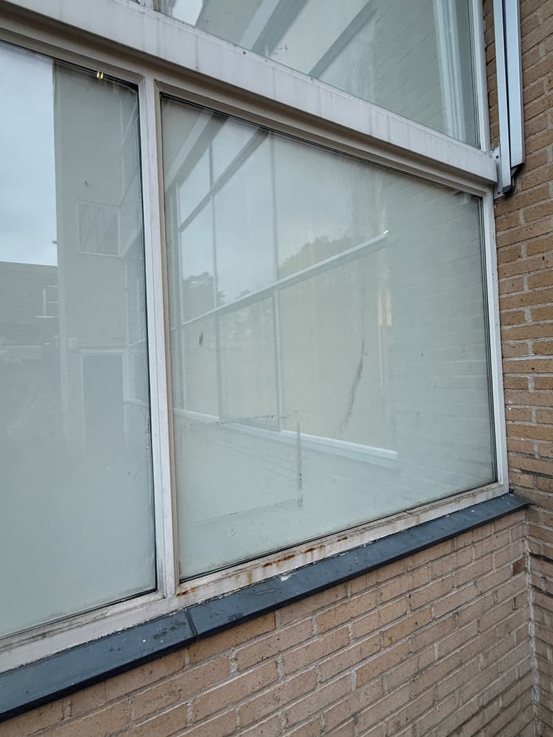 Verouderde raampartij van schoolgebouw